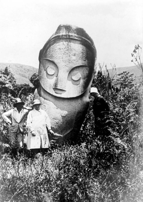FileCOLLECTIE_TROPENMUSEUM_Twee_Europese_dames_en_een_man_staan_voor_een_afgodsbeeld_te_Napu_Menado_TMnr_10000852.jpg