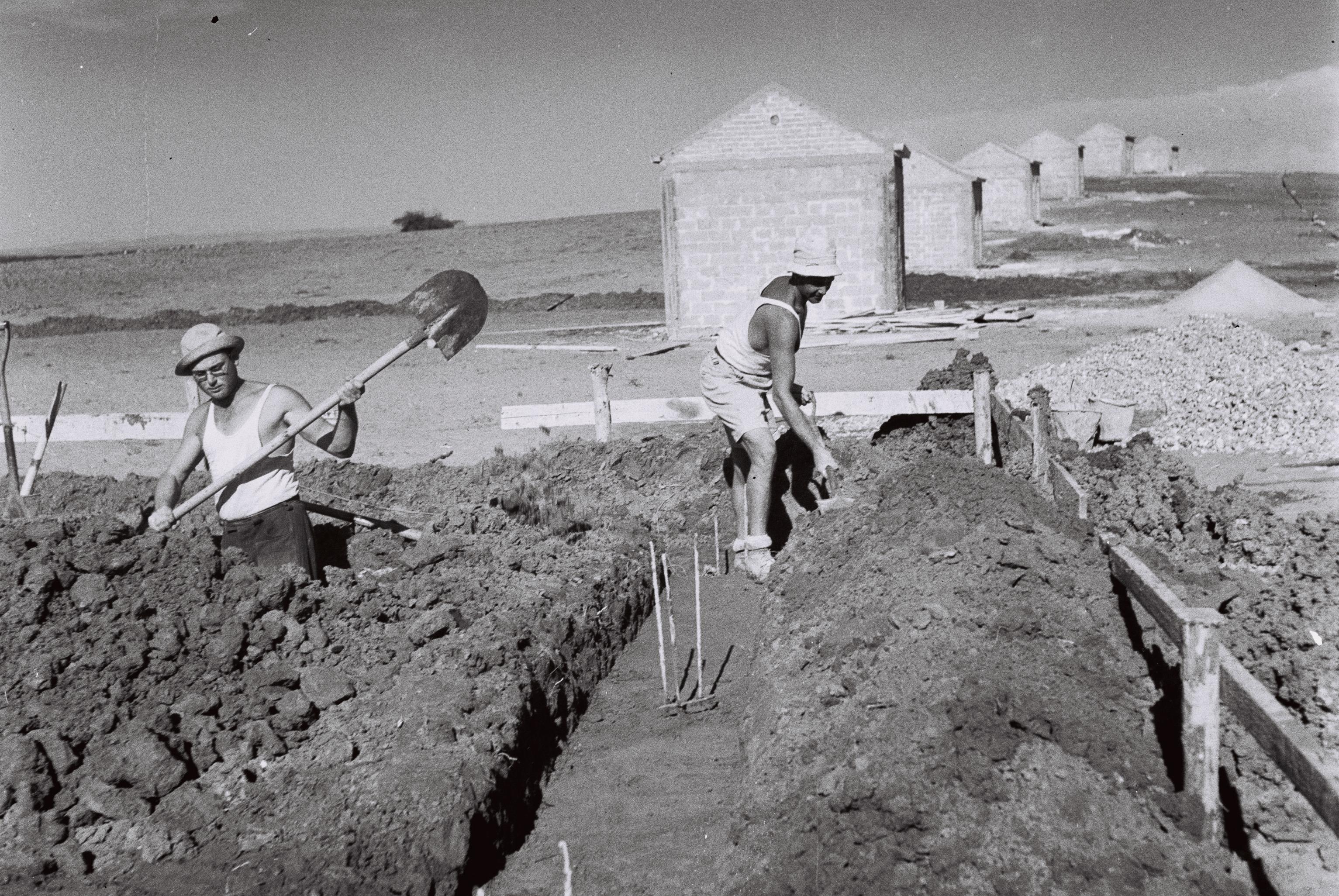 FileBUILDING_WORKERS_LAYING_THE_FOUNDATION_FOR_ONE_OF_THE_NEW_HOUSES_AT_MOSHAV_KFAR_MONASH_IN_THE_HEFER_VALLEY_A_COOPERATIVE_SETTLEMENT_OF_WORLD_WAR_2_VED841-016.jpg